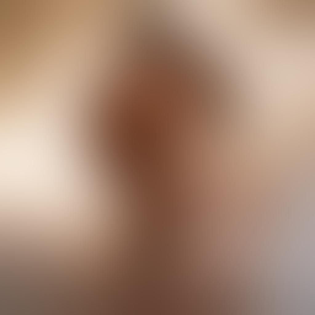 A tastefully composed nude photograph of a couple intertwined in an intimate embrace, showcasing soft natural lighting that highlights the curves of their bodies. The background features a dreamy, blurred landscape, enhancing the sensual mood while maintaining an artistic feel. Incorporate elements like delicate silk sheets and gentle shadows to evoke warmth and depth. artistic photography. soft focus. warm tones.